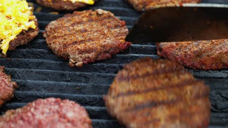 Barbecuing-plant-based-Impossible-Burger-patties-on-electric-grill-semi-close-up-shot-panning-over-spatula-flipped-and-grilled-brown-seasoned-burger-patties---in-Cinema-4k-