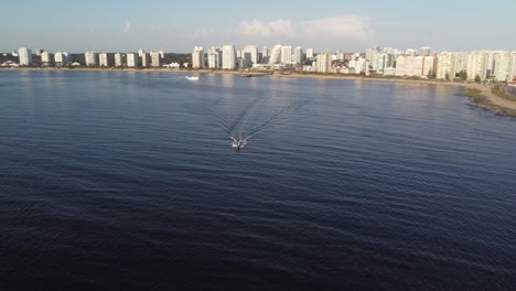 Small-boat-sailing-away-from-Punta-del-Este,-aerial-view