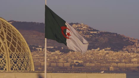 Ciudad-De-Argel-Detrás-De-La-Bandera-De-Argelia-En-La-Gran-Mezquita