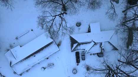 Drone-descending-in-the-early-evening-over-snow-capped-rooves-in-Midwest-USA