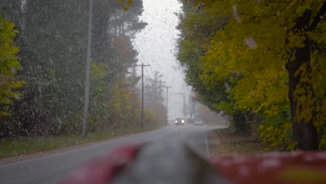Cars-Driving-On-The-Street-During-A-Heavy-Snowfall-While-Colors-Of-Fall-Leaves-Cling-To-The-Trees