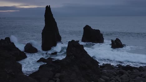 Toma-épica-De-Formación-De-Roca-Oscura-Y-Rocas-De-Pie-En-La-Costa-De-Reykjanes,-Islandia-Durante-El-Día-Místico-Nublado