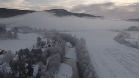Gefrorener-Fluss-Mit-Niedrigen-Wolken-Im-Winter