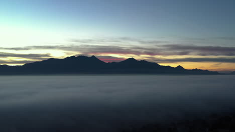 Espesa-Niebla-Sobre-El-Valle-Con-La-Cordillera-A-Lo-Lejos,-Vista-Aérea