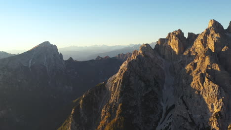 Drone-shot-of-Tre-Cime-di-Lavaredo-a-mountain-range-in-Italy,-slowly-rotating-with-the-sun-setting