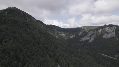 Reverse-plane-drone-video-flying-over-the-Triglav-mountains-in-the-Bohinj-area-in-Slovenia-with-a-clear-sky-with-clouds