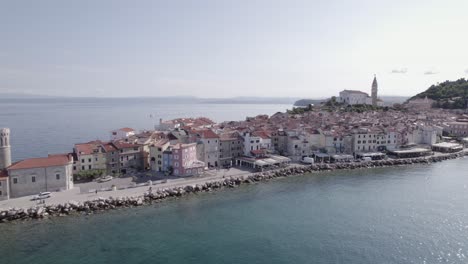 Drone-video-of-side-shot-"slider"-of-the-city-of-Piran-in-Slovenia,-starting-at-the-Lighthouse-to-the-right-discovering-the-city-and-the-church