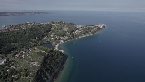 Video-Mit-Beschreibendem-Drohnenschwenk-über-Der-Küste-Sloweniens-Mit-Der-Stadt-Piran-Als-Hauptteil-Der-Szene