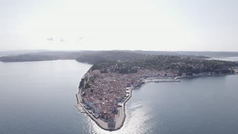 Video-with-a-bird's-eye-view-of-the-lighthouse-of-the-city-of-Piran-in-Slovenia,-with-the-church-in-the-background