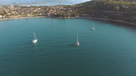 Luftbild-Von-Drei-Segelbooten-In-Einer-Meeresbucht-Mit-Klarem-Wasser,-Umgeben-Von-Wilder-Vegetation-An-Der-Küste-Ostsardiniens