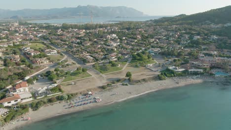 Drone-footage-of-sardinia-coastline-seascape-during-summer-holidays-season,-umbrella-sand-beach-travel-destination