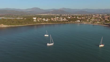 Drone-fly-above-three-sail-luxury-boat-in-east-coastline-of-Sardinia-island-during-golden-hours