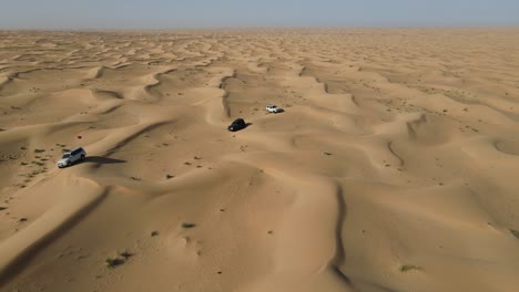 4K:-Drone-view-of-the-group-of-4x4-during-the-desert-safari-in-the-Al-Qudra-desert-of-Dubai,-United-Arab-Emirates