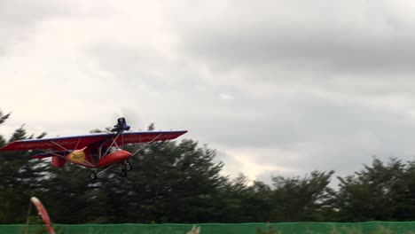 Two-seater-trike-ultralight-aircraft-taking-off-from-air-strip