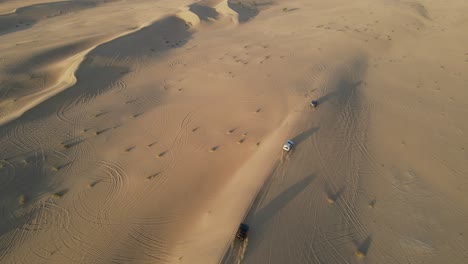 4k:-Drone-Rastreando-Al-Grupo-De-4x4-Durante-El-Safari-Por-El-Desierto-En-El-Desierto-De-Al-Qudra-De-Dubai,-Emiratos-árabes-Unidos