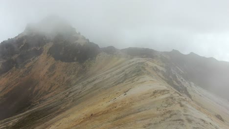 Drone-Volando-A-Través-De-La-Nube-Para-Revelar-Una-Montaña-De-Roca-Volcánica-En-Los-Andes
