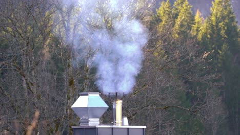 Steam-rises-from-modern-chimney-on-cold-day