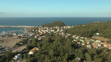 Aerial-view-of-Arbatax-sardinia-coastline-travel-destinations,-little-village-with-port-for-ferry-and-luxury-boat