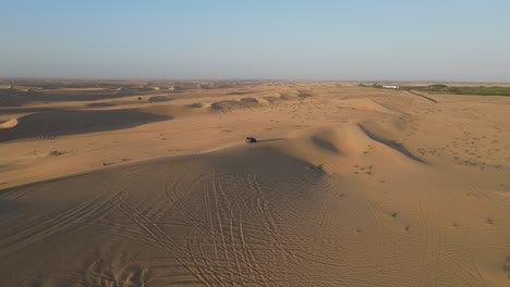 4K:-Drone-view-of-a-4x4-during-the-desert-safari-in-the-Al-Qudra-desert-of-Dubai,-United-Arab-Emirates