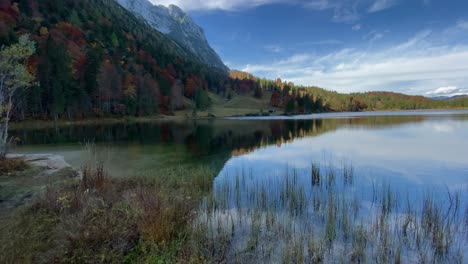 Toma-Panorámica-Del-Lago-Ferchen,-Que-Refleja-Los-Picos-De-Las-Montañas-Karwendel-En-El-Fondo,-Muy-Cerca-De-La-Ciudad-Bávara-De-Mittenwald-En-Alemania