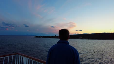Back-view-of-man-with-dark-brown-hair-and-a-blue-jacket-looking-at-clouds