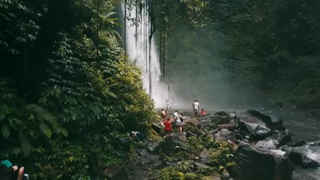 Bali,-Spring-2020-in-1080-60p,-Daytime,-cinematic-drone-flight-Long-slow-motion-backward-flight-from-waterfall-over-a-small-group-of-tourists