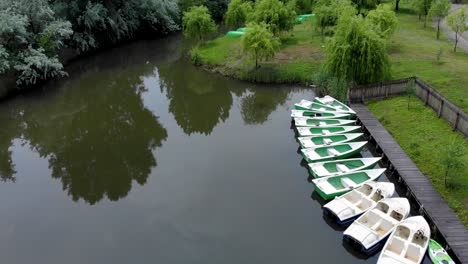 Kleine-Boote-Im-See-Mit-Grünen-Weiden-Im-Sommer