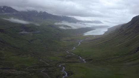 Aerial-flyover-idyllic-Mjóifjörður-Fjord-during-cloudy-grey-day-in-East-of-Iceland