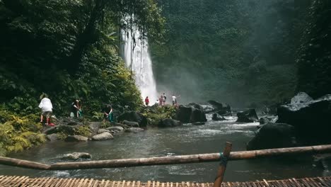 Bali,-Spring-2020-in-1080-60p,-Daytime,-cinematic-drone-flight-Long-slow-motion-flight-to-the-waterfall-over-the-river-to-a-small-group-of-tourists-over-an-indigenous-bridge