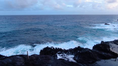 Hawaiianisches-Blasloch,-Das-An-Einem-Bewölkten-Tag-Aktiv-Ist,-Wenn-Raue-Wellen-Auf-Die-Riffklippe-Stürzen