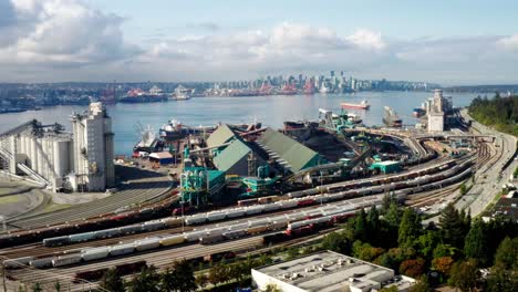 Luftaufnahme-Von-Kesselwagen-Der-Öl--Und-Erdgasgesellschaft,-Die-Auf-Der-Eisenbahn-Geparkt-Sind,-Mit-Blick-Auf-Den-Burrard-Einlass-Und-Die-Skyline-Der-Innenstadt-Von-Vancouver-In-Kanada