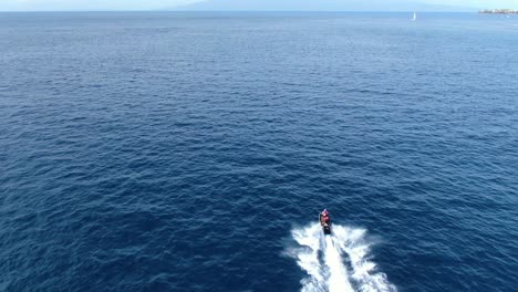 drone-following-two-people-riding-a-jetski-in-the-hawaiian-ocean