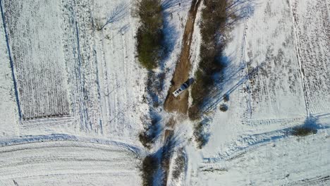Aerial-view-of-a-van-turning-around-on-a-dirt-road-in-the-middle-of-the-fields-on-a-sunny-winter-day,-Dalmatia,-Croatia