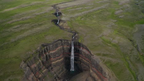 Aerial-birds-eye-shot-of-breathtaking-landscape-with-famous-vast-Hengifoss-Waterfall-in-Iceland