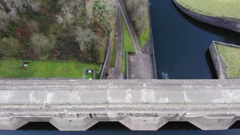 Aerial-Over-Path-With-People-Walking-Past-On-Wimbleball-Lake-Dam