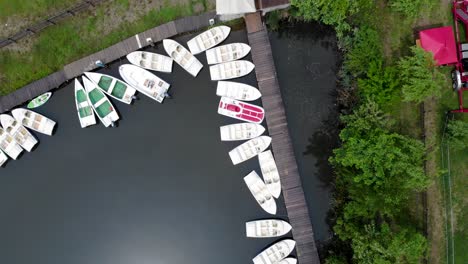 Aerial-View-Of-Small-Boats-Moored-By-The-Wooden-Jetty-In-The-Lake