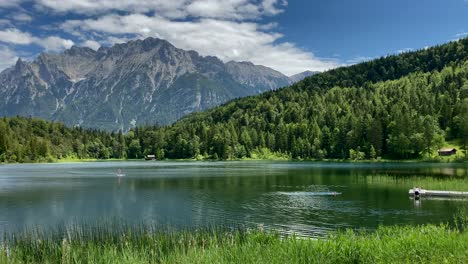 Lago-Lauter-En-Verano-Con-Stand-Up-Paddle-Y-Montañas-Karwendel-En-El-Fondo,-Muy-Cerca-De-La-Ciudad-Bávara-De-Mittenwald-En-Alemania