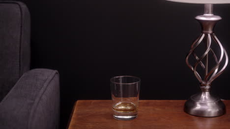 Ein-Mann-Nimmt-Ein-Glas-Scotch-Vom-Tisch
