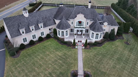 Sprawling-mansion-home-decorated-with-Christmas-wreath-and-lights