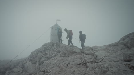 Hikers-arriving-at-the-peak-of-mountain-Triglav-in-front-of-Aljaž-Tower