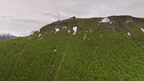 Tromsø-Norway-Aerial-v14-cinematic-drone-slowly-fly-up-to-the-mountain-ledge-of-mount-storsteinen,-birds-eye-view-overlooking-at-fjellheisen-cable-car-station---Shot-with-Mavic-3-Cine---June-2022
