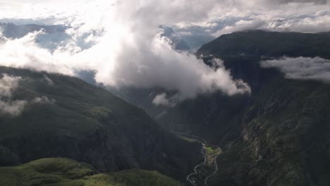 Hohe-Weiße-Wolken-Bewegen-Sich-Langsam-über-Die-Kurvenreiche-Straße-Und-Den-Fluss-Im-Tal-Zwischen-Den-Hohen-Grünen-Bergen-Im-Hardangervidda-nationalpark-In-Norwegen