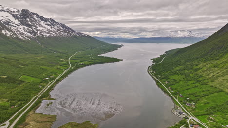 Nordkjosbotn-Norway-v3-drone-flyover-water-inlet-in-between-mountain-valley-capturing-pristine-nature-landscape-with-mountaintop-covered-in-snow-on-a-cloudy-day---Shot-with-Mavic-3-Cine---June-2022