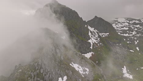 Djevelporten-Norway-Aerial-V7-Filmische-Ansicht-Drohne-Flyover-Bergkämme,-Schneeflecken-Auf-Felsiger-Oberfläche,-Atmosphäre-Bedeckt-Mit-Einer-Dicken-Schicht-Mysteriösen-Nebels---Aufgenommen-Mit-Mavic-3-Cine---Juni-2022