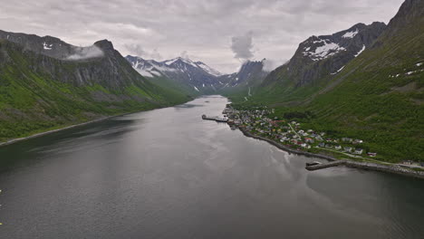 Gryllefjord-Norway-Aerial-v4-flyover-inlet-capturing-small-fishing-village-with-aquaculture-net-cage-on-norwegian-fjord-surrounded-by-beautiful-mountain-landscape---Shot-with-Mavic-3-Cine---June-2022