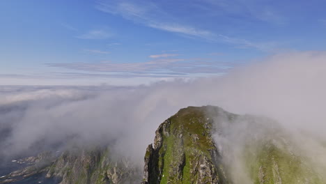 Stave-Norway-Aerial-v19-high-altitude-drone-fly-around-måtind-viewpoint-capturing-dramatic-rocky-mountain-peak-and-coastal-mountainscape-with-thick-layer-of-fogs---Shot-with-Mavic-3-Cine---June-2022