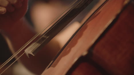 Super-close-footage-of-a-man-playing-a-cello-with-his-hands-with-a-shallow-depth-of-field