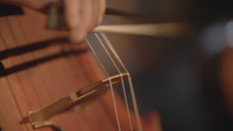 Super-close-footage-of-a-man-playing-a-cello-with-a-bow-with-a-shallow-depth-of-field