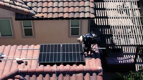 Luftaufnahme-Des-Installateurs-Auf-Dem-Dach-Des-Hauses,-Der-Sonnenkollektoren-Installiert,-Grünes-Energiekonzept,-Drohnenaufnahme