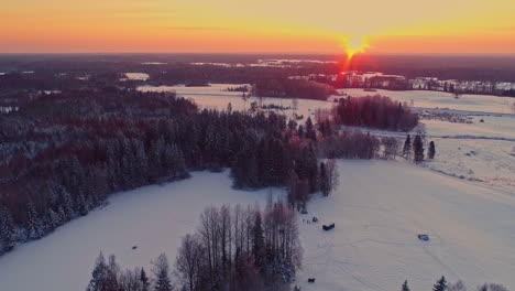 People-Playing-In-Snow-Outside-Wooden-Cabin-In-Latvia-At-Sunset
